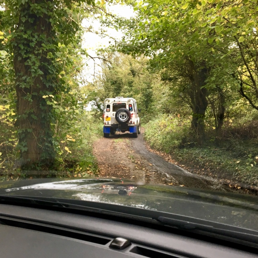 following a Land Rover defender through the woods